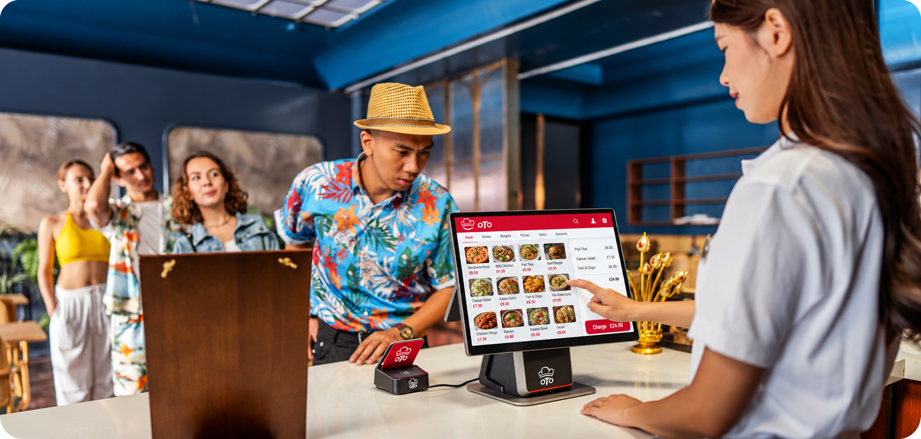 A server taking an order on an OTO-branded counter terminal, with a card payment device beside it